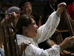 Seorang wisatawan terlihat ceria ketika belajar memainkan angklung di Saung Angklung Udjo