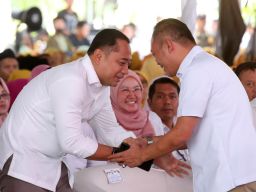 Walikota Surabaya Eri Cahyadi (kiri) berjabat tangan dengan Kepala Kantor Wilayah BPJS Ketenagakerjaan Jawa Timur, Hadi Purnomo, saat penyerahan simbolis Kartu Peserta BPJS Ketenagakerjaan (KPJ)