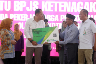 Walikota Surabaya Eri Cahyadi menyerahkan simbolis Kartu Peserta BPJS Ketenagakerjaan (KPJ) kepada Pekerja Warga Pelayan Masyarakat di Taman Surya Balai Kota Surabaya, Rabu (11/9/2024). Foto/Alim Perdana