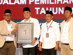 Eri Cahyadi-Armuji diapit Ketua KPU Surabaya, Soeprayitno (kanan), dan anggota KPU Surabaya, Subairi (kiri) dalam acara Rapat Pleno Terbuka Pengundian dan Penetapan Nomor Urut Pasangan, di Surabaya, Jawa Timur, Senin (24/9/2024).