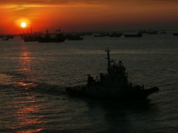 Perahu melintas dengan latar belakang sunset di Pelabuha Tanjung Perak Surabaya