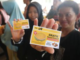 Warga menunjukkan kupon gratis bantal eksklusif. Pembukaan McDonald’s Jombang juga diwarnai dengan kegiatan berbagi kepada masyarakat sekitar