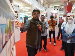 Anngota PFI Surabaya, Dipta Wahyu, menjelaskan karya foto ketika menjadi moderator Workshop Fotografi "Ngonten Ala Jurnalistik", di Atrium Royal Plaza Surabaya