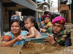 Prajurit Korps Marinir TNI AL mengevakuasi anak yang terjebak banjir dengan perahu karet
