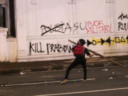 Demonstran berusaha melempar bambu ke arah aparat ketika aksi tolak RUU TNI di Surabaya