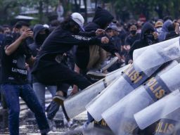 Demonstran berusaha menjebol pertahanan aparat ketika aksi tolak RUU TNI di Surabaya