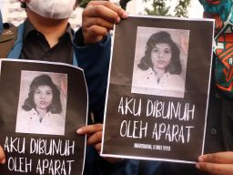 Massa aksi membawa foto Marsinah ketika menggelar aksi peringatan Hari Buruh atau May Day 2025 di depan Gedung Negara Grahadi, Jalan Gubernur Suryo, Surabaya