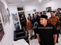 Dari kiri-kekanan Ketua Komisi Pemilihan Umum (KPU) RI Mochammad Afifuddin, Ketua KPU Jatim Aang Kunaifi dan Divisi Sosialisasi; Pendidikan Pemilih dan Partisipasi Masyarakat KPU Jatim Nur Salam melihat foto-foto. Foto: Robertus Risky/Ayo Jatim