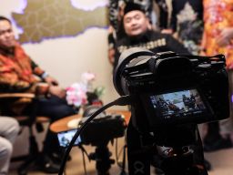 Ketua Komisi Pemilihan Umum (KPU) RI, Mochammad Afifuddin didampingi Ketua KPU Jatim Aang Kunaifi, serta para komisioner dan seluruh jajaran Sekretariat KPU Jatim. Saat berada di ruang podcast . Foto: Robertus Risky/Ayo Jatim