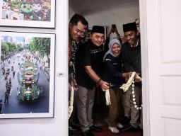 Ketua Komisi Pemilihan Umum (KPU) RI Mochammad Afifuddin (dua kiri) didampingi Ketua KPU Jatim Aang Kunaifi (kiri), serta para komisioner dan seluruh jajaran Sekretariat KPU Jatim. Saat pelucuran ruang podcast . Foto: Robertus Risky/Ayo Jatim