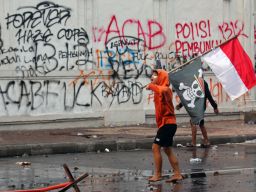 Demontran membawa bendera one peace saat demo yang berujung ricuh di depan Gedung Negara Grahadi, Surabaya, pada Jumat, 29 Agustus 2025.