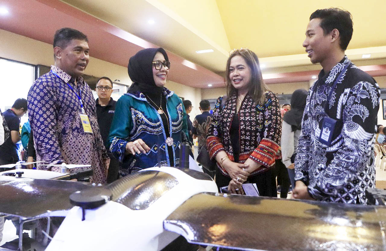 Rektor Unitomo Prof Siti Marwiyah melihat alat survei yang dipamerankan dalam gelaran simposium nasional di Unitomo Surabaya. Foto/Humas Unitomo