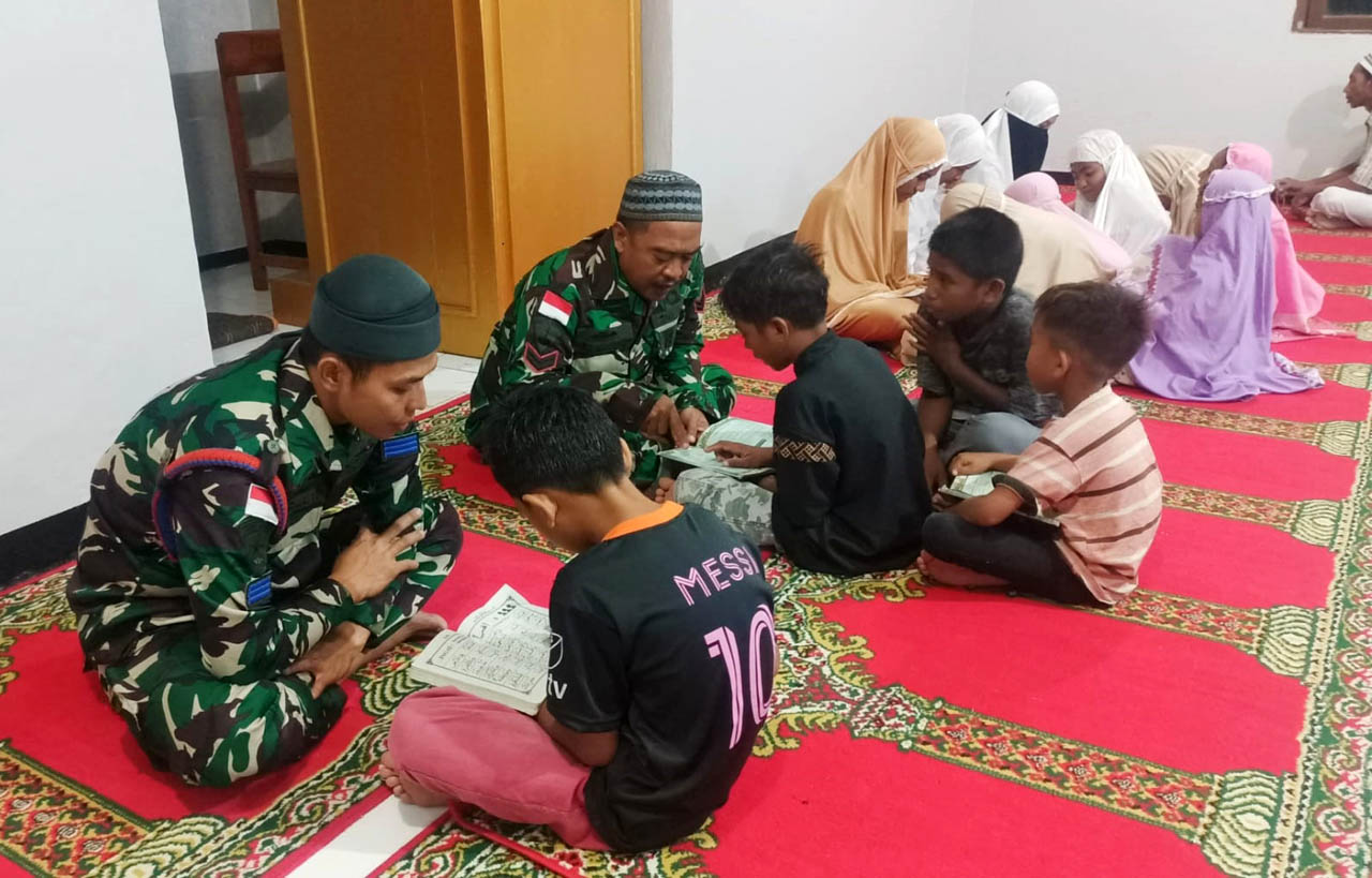 Sertu Mar Abu Lukman dan Praka Mar M. Abdul Karim mengajarkan cara membaca Alquran di daerah penugasan. Foto/Dispen Kormar