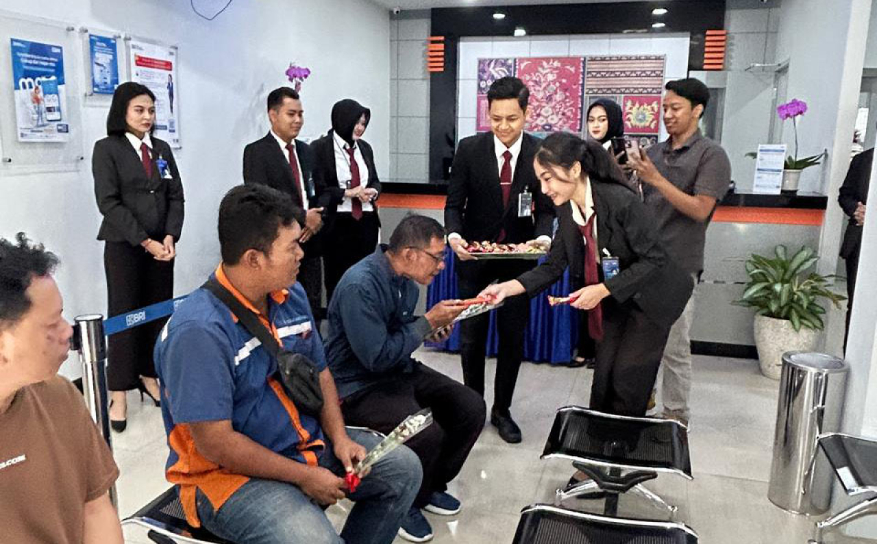 Pimpinan BRI Surabaya BO Diponegoro bersama jajaran menyapa nasabah yang datang pada pagi hari dan memberi bunga dan cokelat sebagai bentuk tali kasih BRI kepada nasabahnya. Foto/AyoJatim