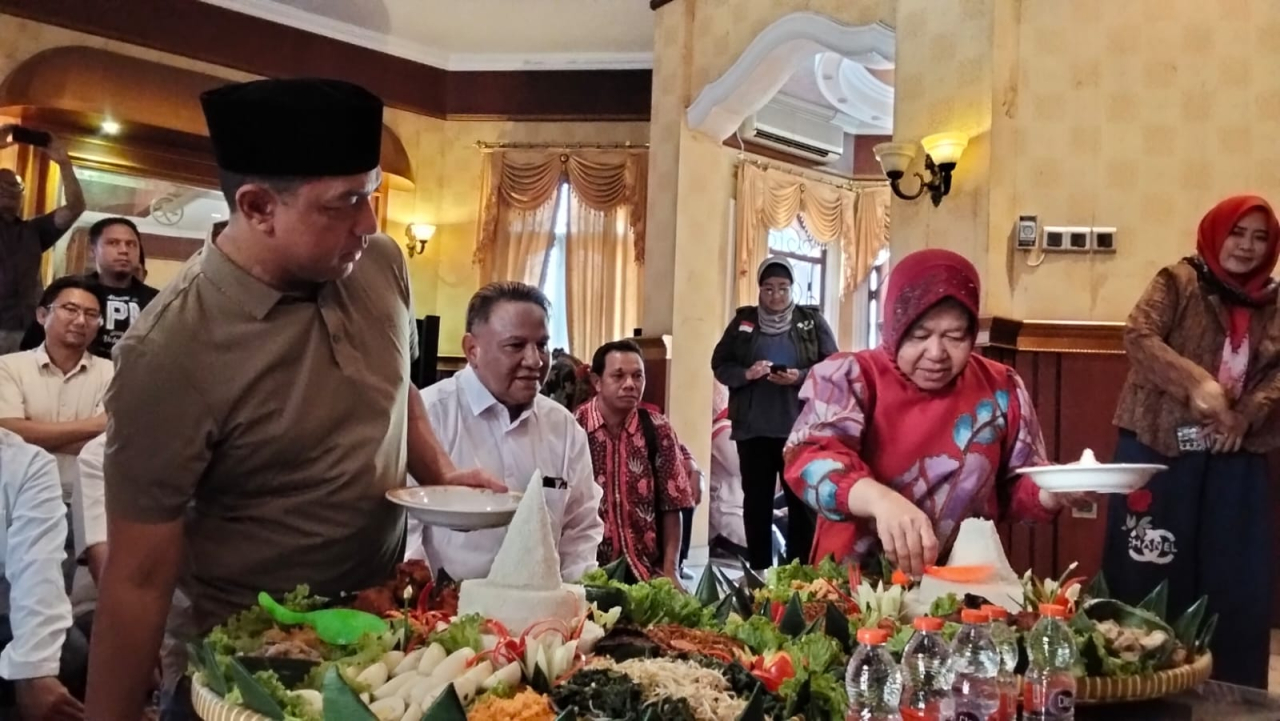 Tri Rismaharini dan KH Zahrul Azhar Asumta potong tumpeng saat meresmikan posko pemenangan Risma-Gus Hans ini berada di Jalan Gayungsari Barat, Surabaya. Foto/Tim Media Center