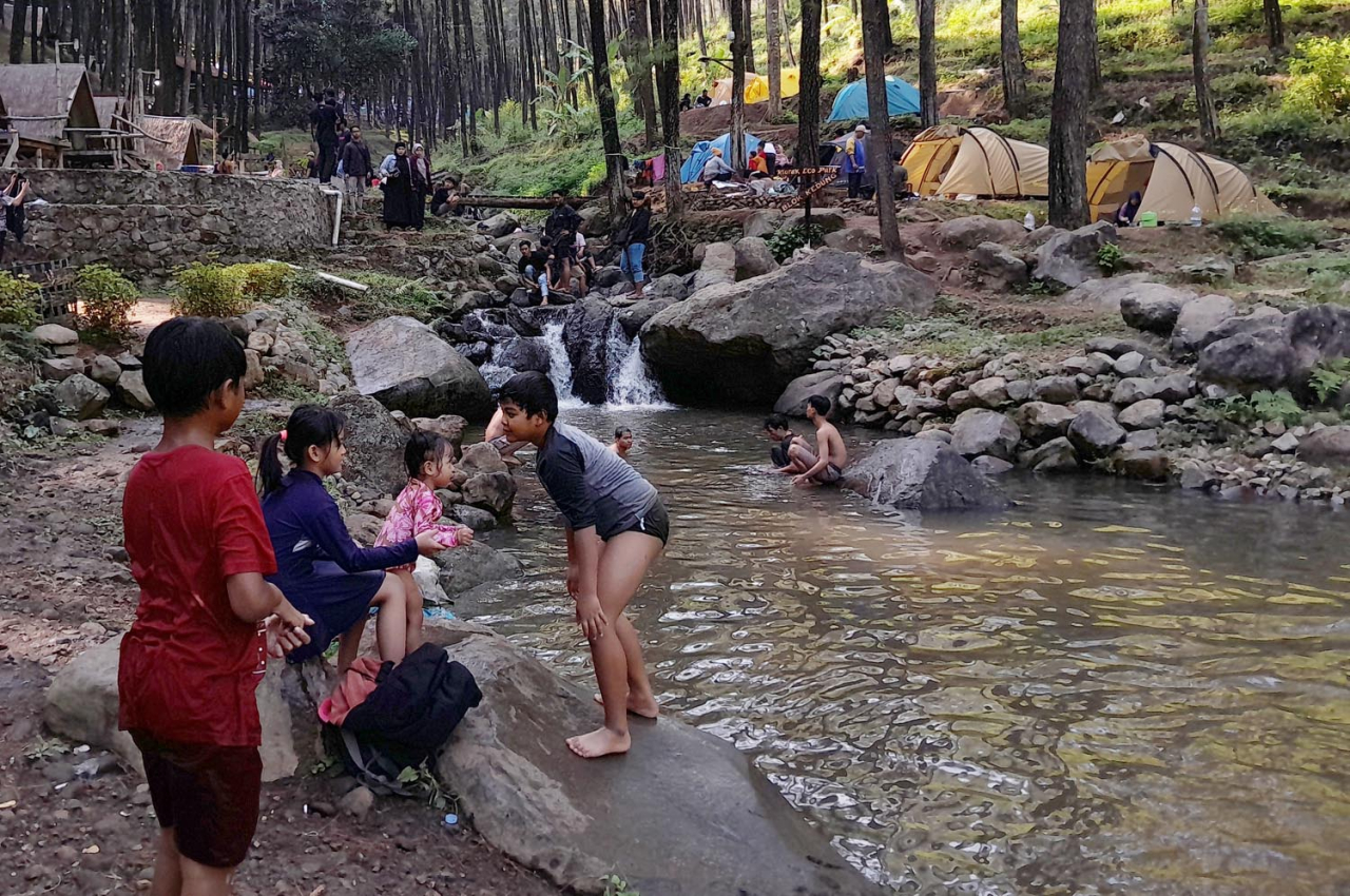 Sejumlah anak bermain di sungai ketika berwisata di Klurak Pacet, Mojokerto. Foto/Alim Perdana