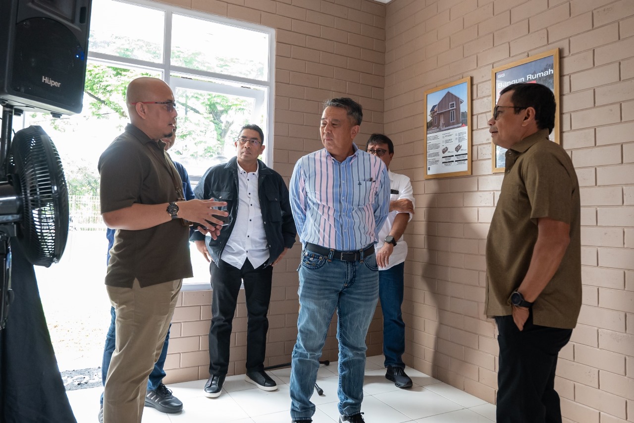 Direktur Utama SIG, Donny Arsal (kanan) bersama Wakil Direktur Utama BTN, Oni Febriarto Rahardjo (tengah) berbincang di dalam rumah contoh Bata Interlock Presisi SIG di Bambu Apus, Jakarta Timur, pada Jumat (27/12/2024). Foto/SIG
