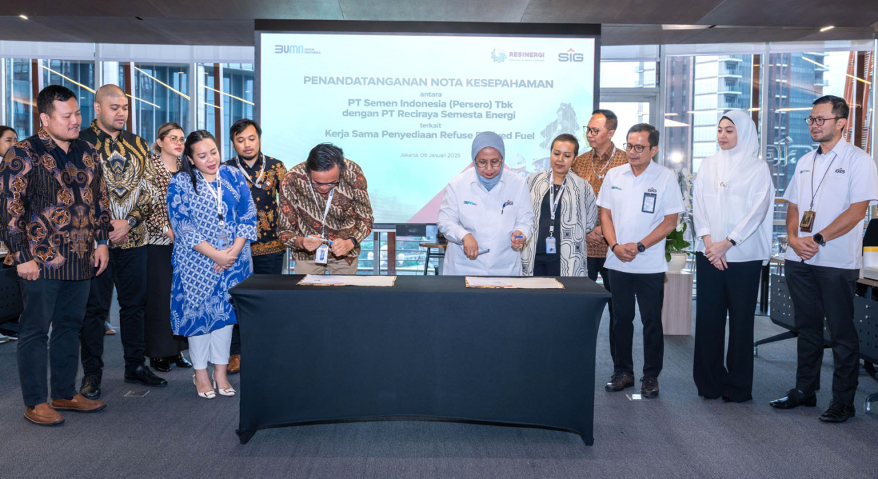 Direktur Operasi SIG, Reni Wulandari dan Direktur Utama RESINERGI, Bhima Aries Diyanto menandatangani Nota Kesepahaman terkait Kerja Sama Penyediaan Refuse-Derived Fuel, disaksikan oleh Direktur Utama SIG, Donny Arsal (ketiga kanan) di Ruang Pleno Kantor 