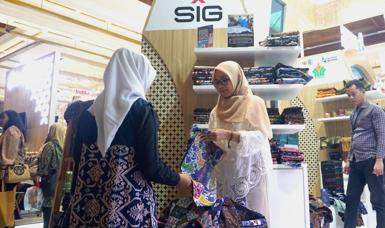 Tim Rumah BUMN SIG melayani pengunjung melihat produk Batik Lasem di booth Rumah BUMN dalam pameran INACRAFT 2025. Foto/SIG