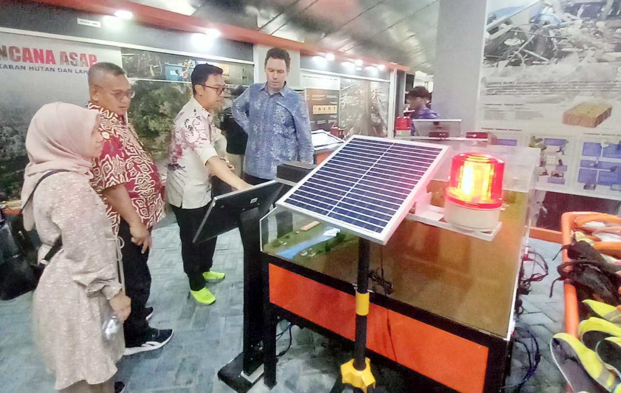 Tim Stapleton, Minister Counsellor Governance and Human Development dari kedubes Australia di Jakarta, sedang mencoba Virtual Reality cara menyelamatkan diri dari lokasi bencana kebakaran di Taman Edukasi Bencana BPBD Jatim, Jumat (7/2/2025). Foto/AyoJati