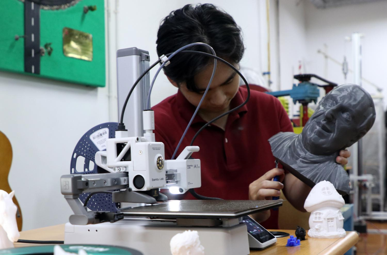 Angelo Franklyn Wijaya, alumnus Prodi Teknik Mesin dan Manufaktur Ubaya saat menunjukkan hasil 3D Printing Wajah Paus Fransiskus, Selasa (29/4/2025). Foto: Ayojatim/Humas Ubaya