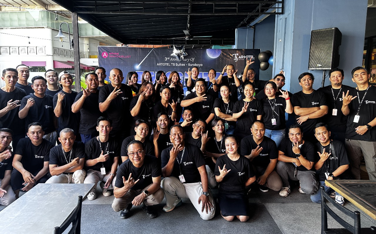 Karyawan Artotel TS Suites Surabaya berfoto bersama dengan manajemen Surabaya Town Square di teras One Deck Gastropub pada Selasa (1/7/2025). Foto/Ayojatim