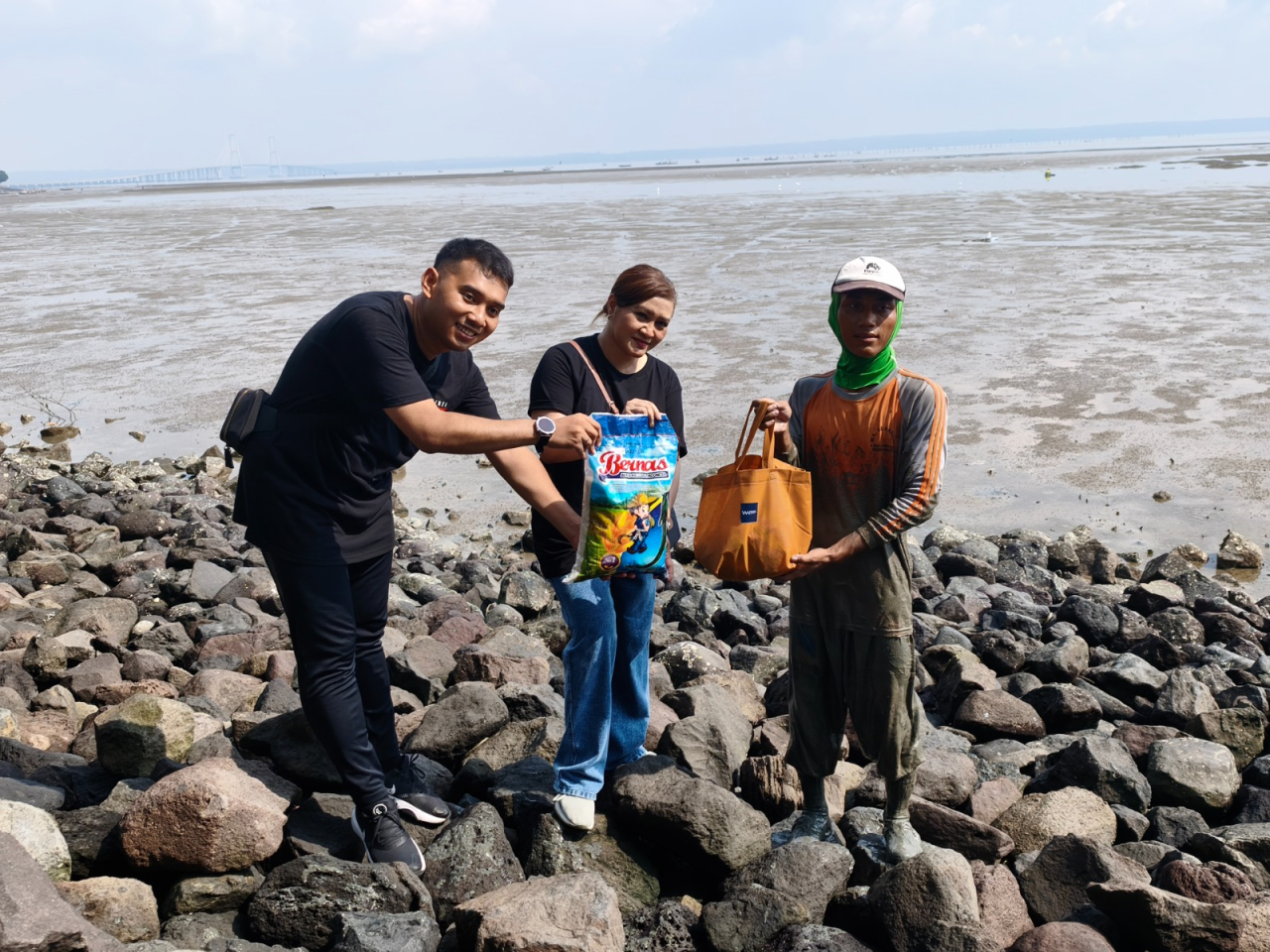 Tim dari Waringin Hospitality Hotel Group menyerahkan sembako kepada salah satu nelayan. Foto: Ayojatim