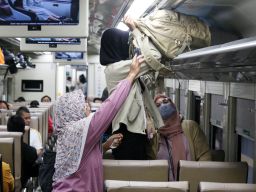 Penumpang kereta api menata barang bawaan di Stasiun Surabaya Gubeng, Selasa (28/1/2025).