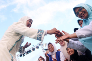 Gubernur Jawa Timur Khofifah Indar Parawansa menyalami warga di halaman Gedung Negara Grahadi, Jalan Gubernur Suryo Nomor 6, Genteng, Surabaya, pada Minggu (2/3/2025)